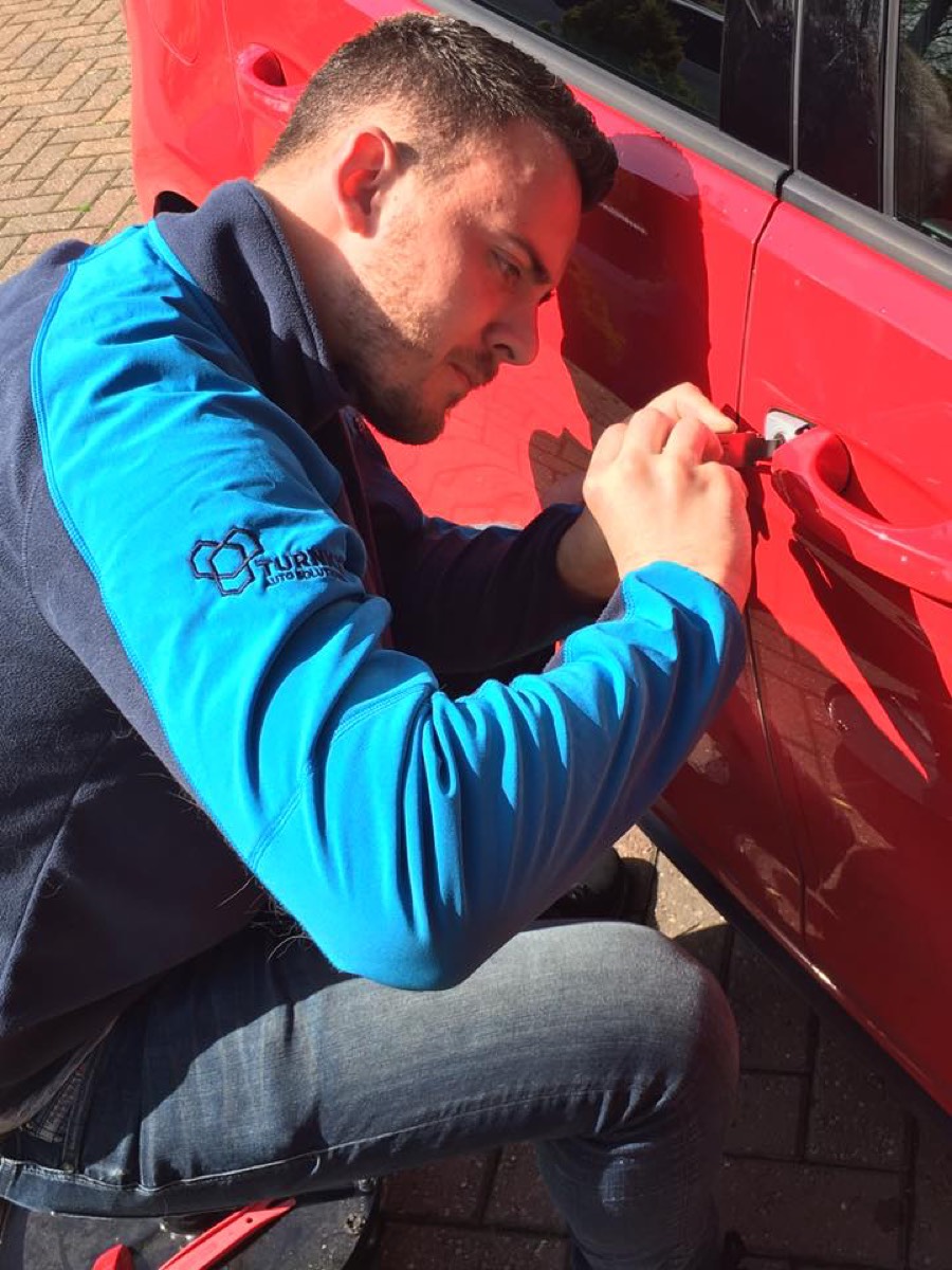 Non-destructive entry being carried out on a red car door