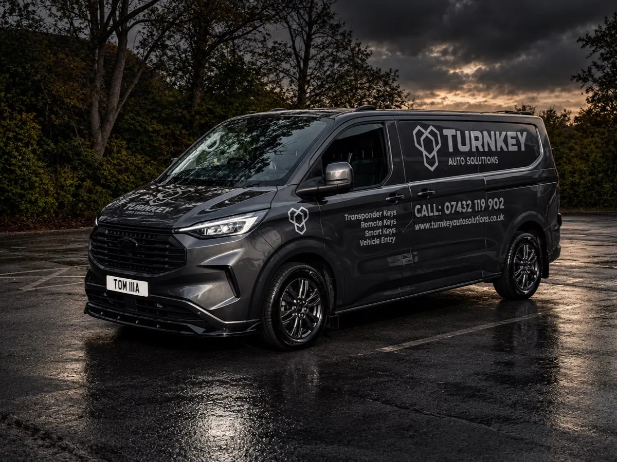 Turnkey Auto Solutions branded Ford Transit Custom van on a wet car park at dusk